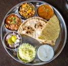 Enjoy a delicious Indian thali showcasing traditional cuisine with various dishes.